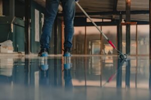 the worker applies gray epoxy resin to the new floor